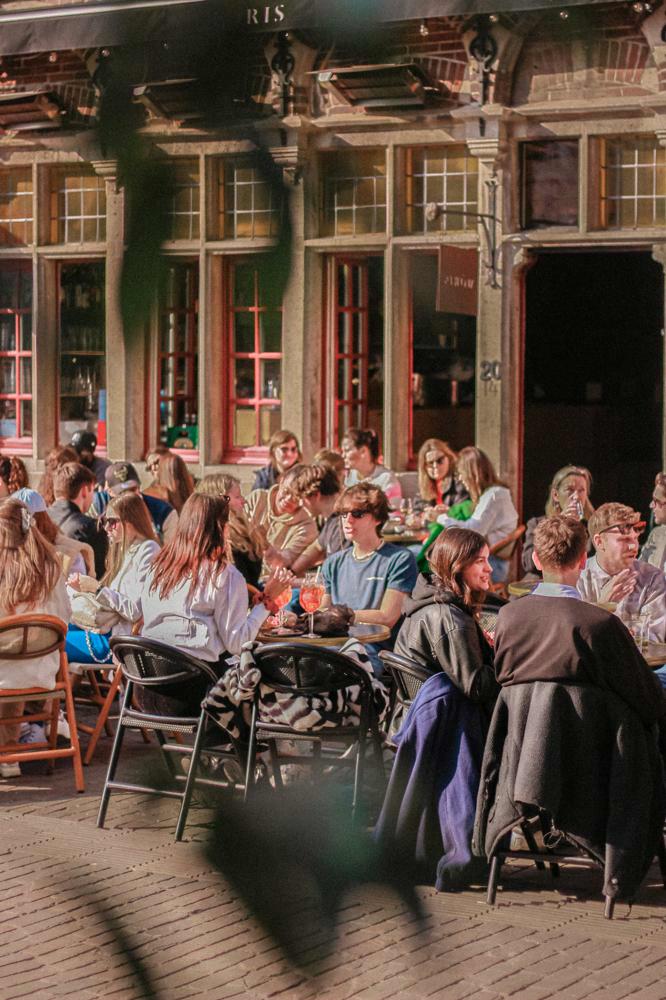 Mensen op zonnig terras in centrum Gent