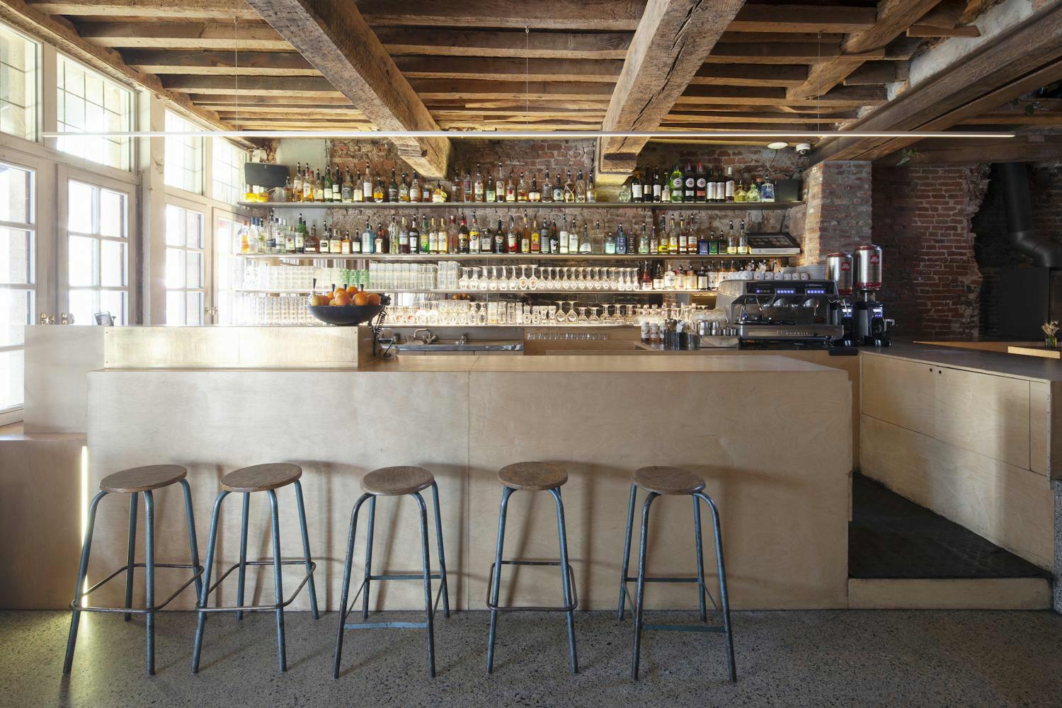 Bar met sterke drank en glazen op schappen in Gent